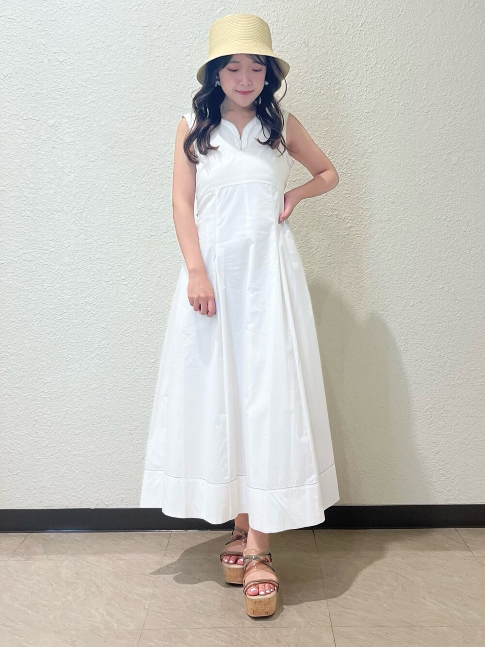 ホワイト系のワンピース、その他のサンダル、ベージュ系のハットを着用したレディースの春コーディネートの1枚目の写真