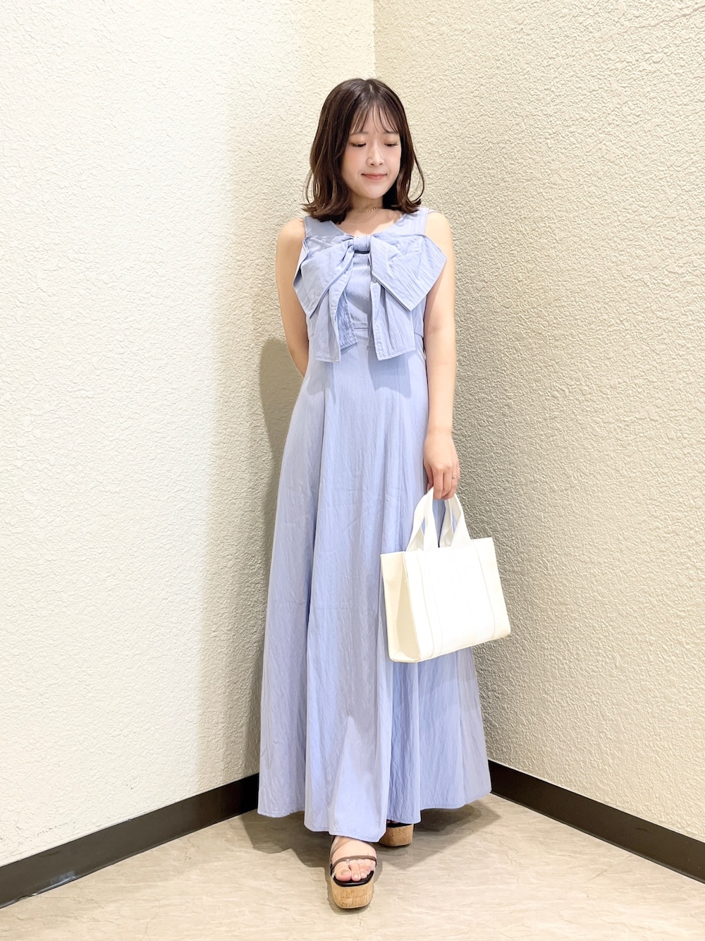 ブルー系のワンピース、ホワイト系のトートバッグ、ブラック系のサンダルを着用したレディースの夏コーディネートの1枚目の写真