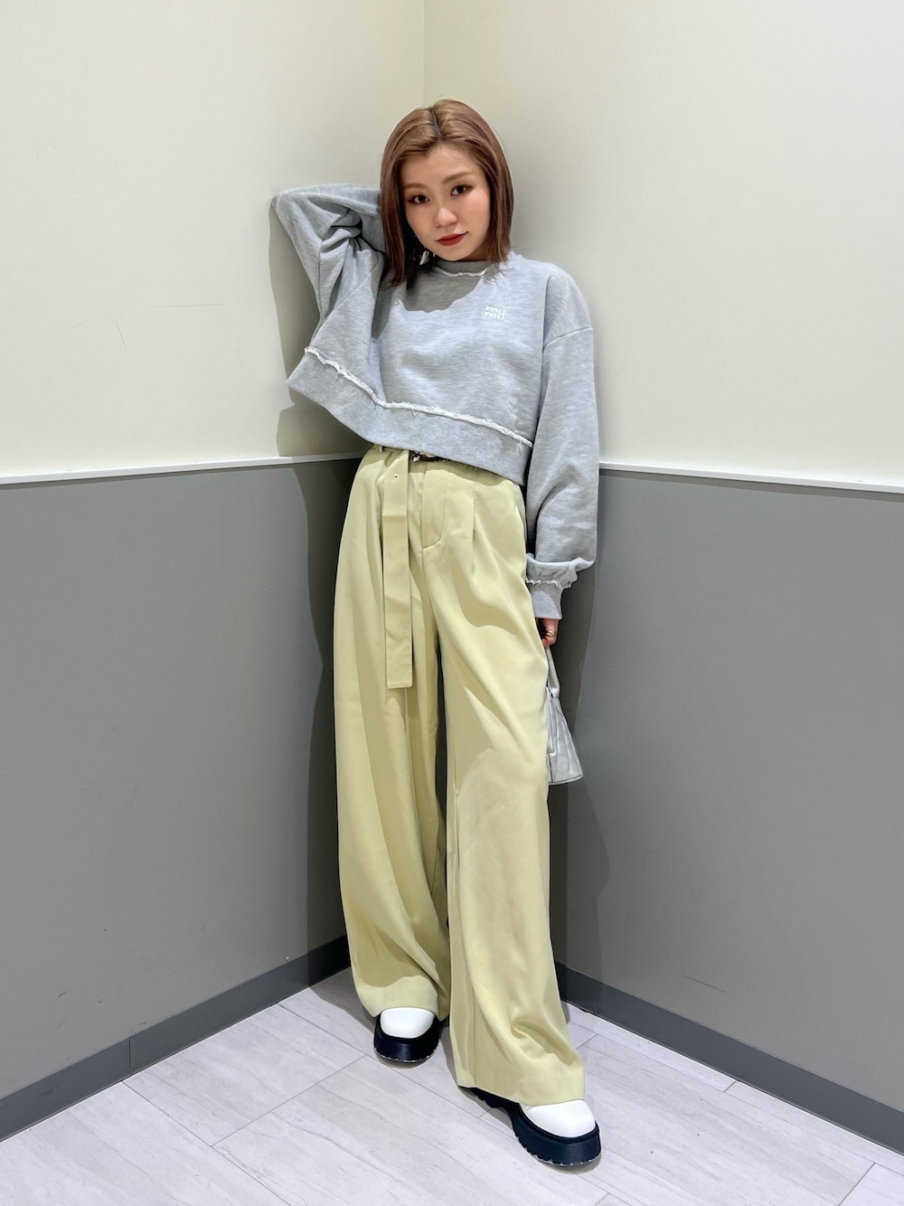 グレー系のスウェット、グリーン系のその他パンツ、シルバー系のハンドバッグを着用したレディースの冬コーディネートの1枚目の写真