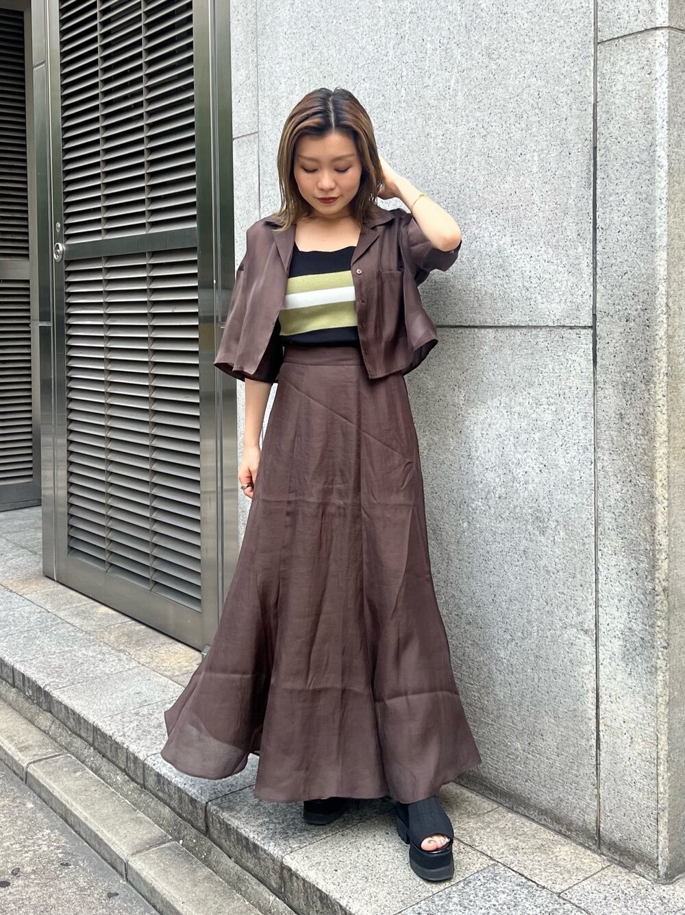 ブラック系のブーツ、その他のニット/セーター、ブラウン系のスカートを着用したレディースの夏コーディネートの1枚目の写真