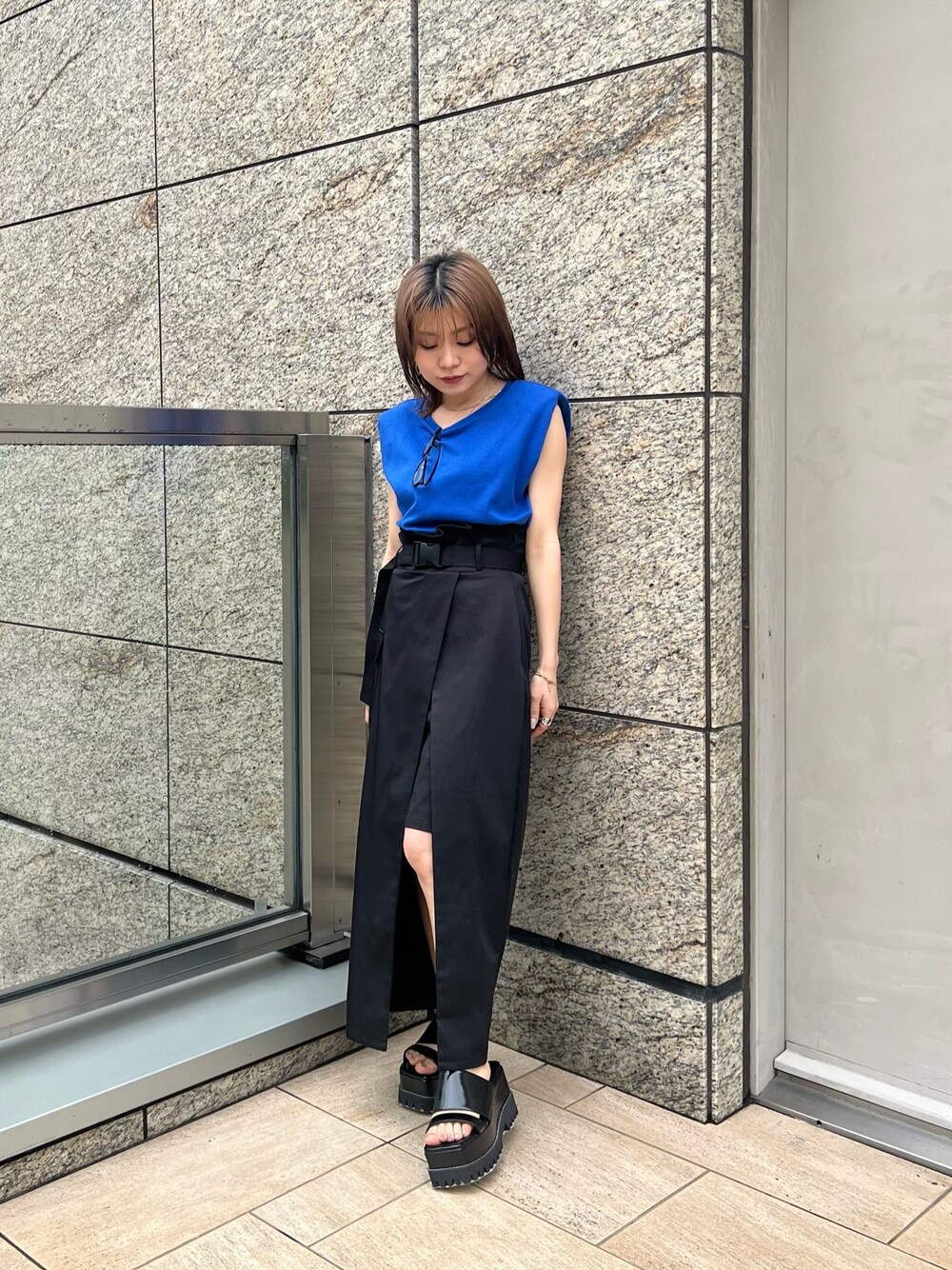 ブラック系のスカート、ブラック系のサンダル、ブルー系のTシャツ/カットソーを着用したレディースの夏コーディネートの1枚目の写真