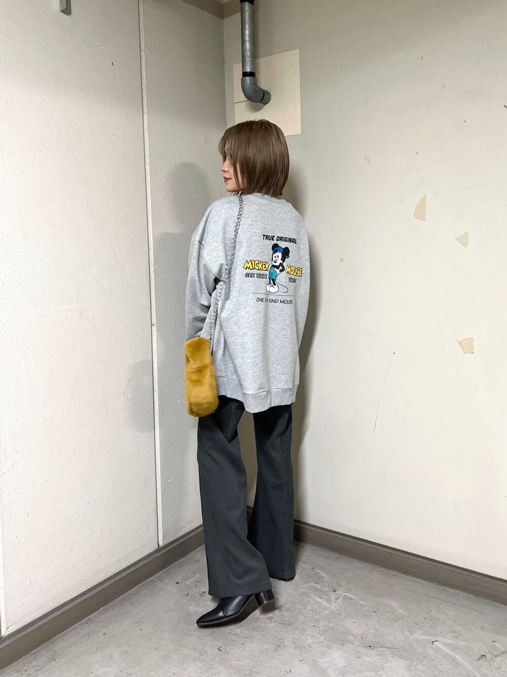 グレー系のスウェット、グレー系のその他パンツ、イエロー系のハンドバッグを着用したレディースの秋コーディネートの1枚目の写真