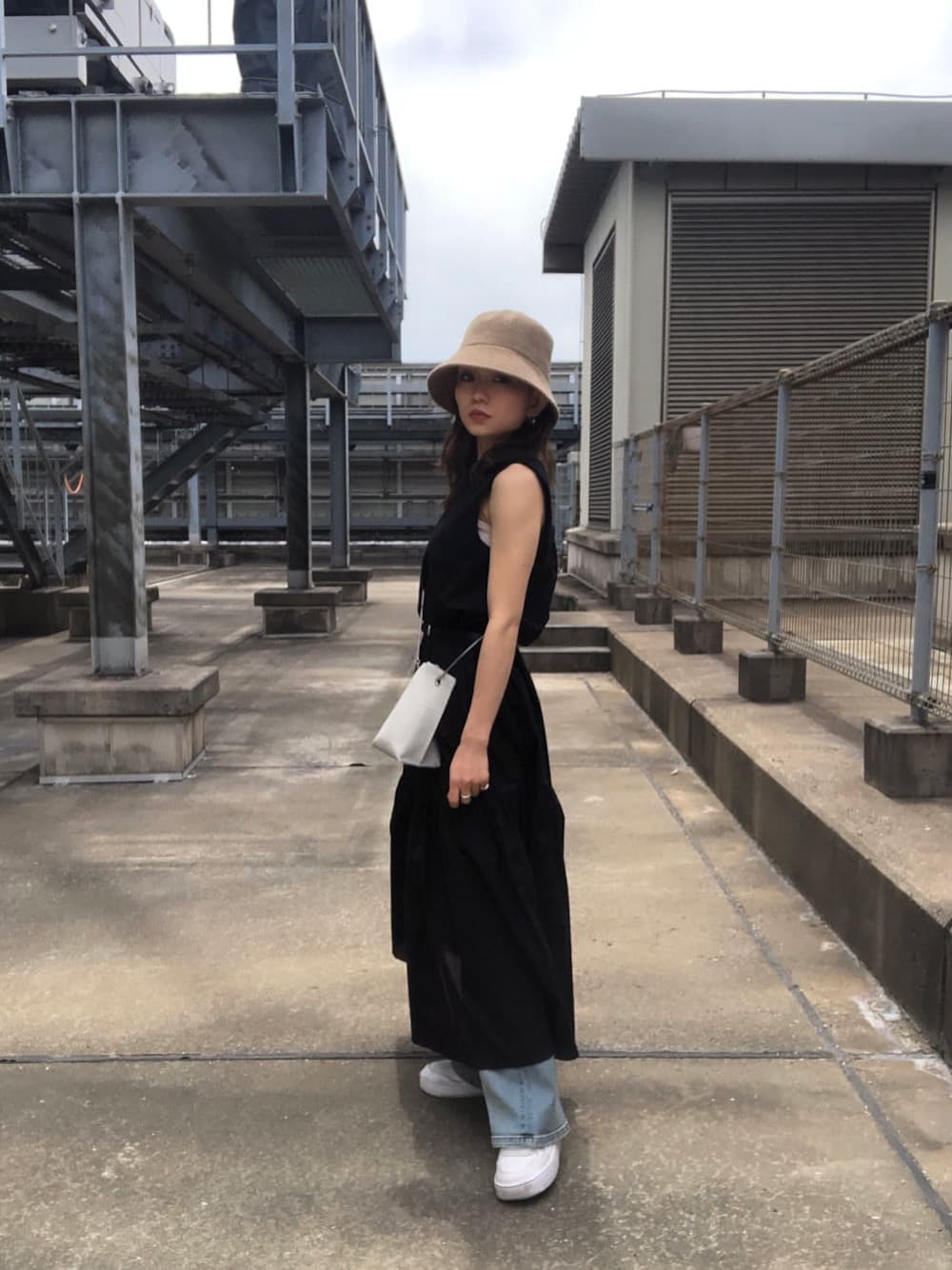 ブラック系のワンピース、ホワイト系のショルダーバッグ、ベージュ系のハットを着用したレディースの夏コーディネートの1枚目の写真