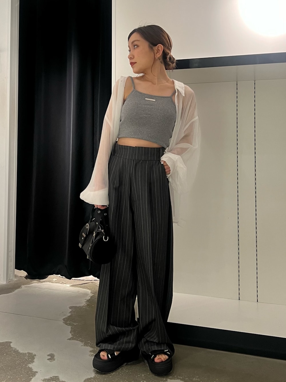 ホワイト系のシャツ/ブラウス、グレー系のキャミソール、グレー系のスラックスを着用したレディースの春コーディネートの1枚目の写真