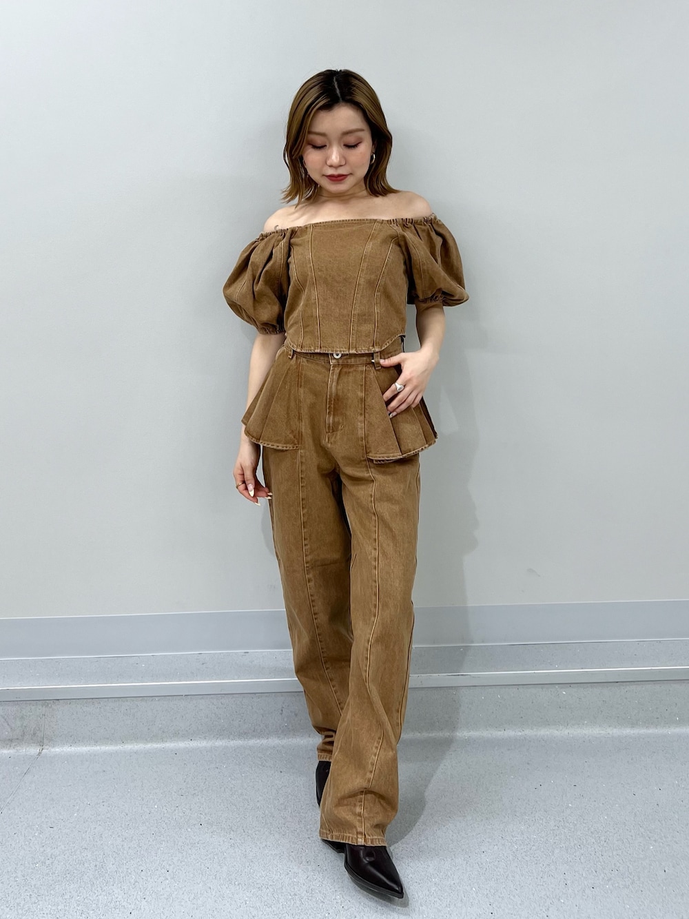 ブラウン系のシャツ/ブラウス、ブラウン系のデニムパンツ、ブラウン系のブーツを着用したレディースの春コーディネートの1枚目の写真