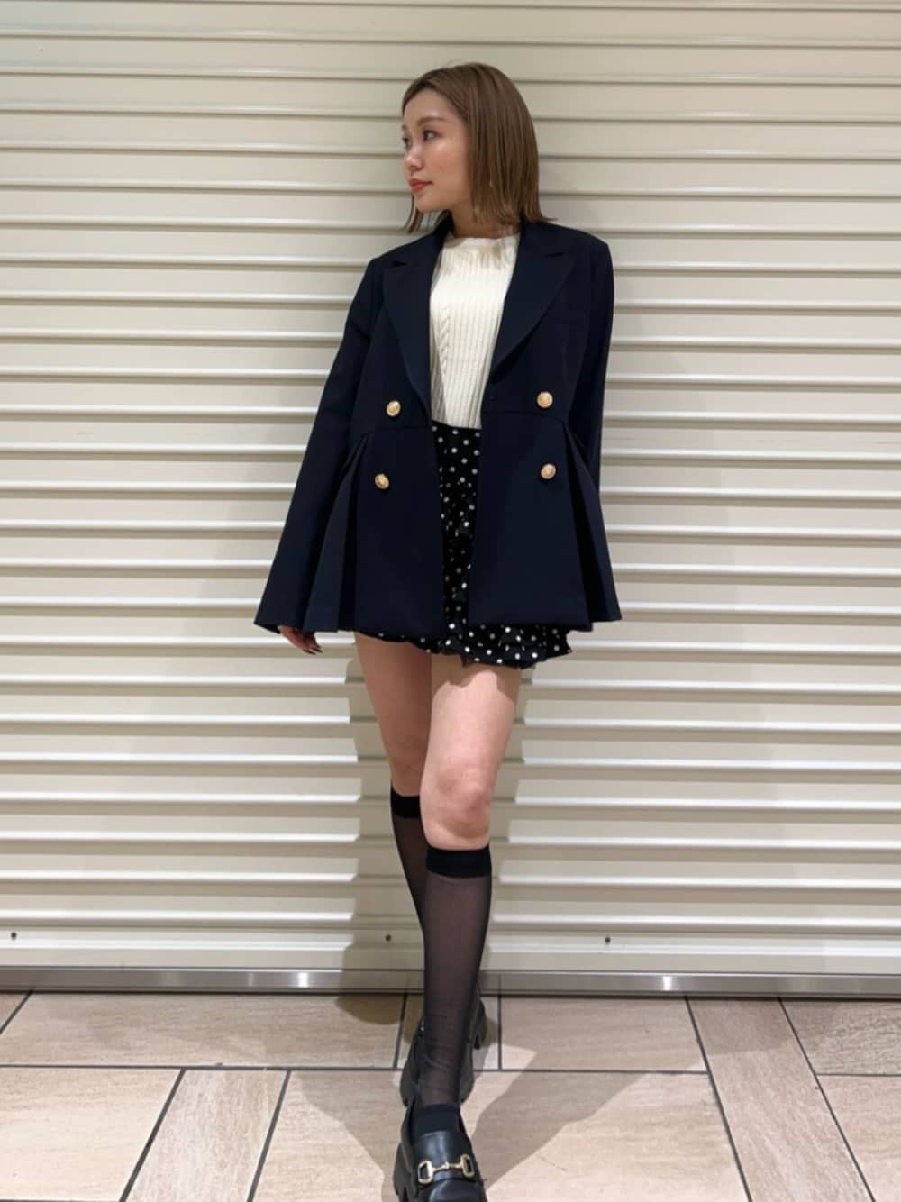 グレー系のニット/セーター、ブラック系のその他パンツ、ブルー系のノーカラージャケットを着用したレディースの冬コーディネートの1枚目の写真