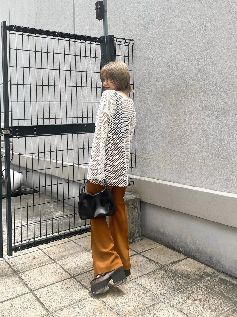 オレンジ系のその他パンツ、ブラック系のサンダル、ブラック系のハンドバッグを着用したレディースの夏コーディネートの1枚目の写真