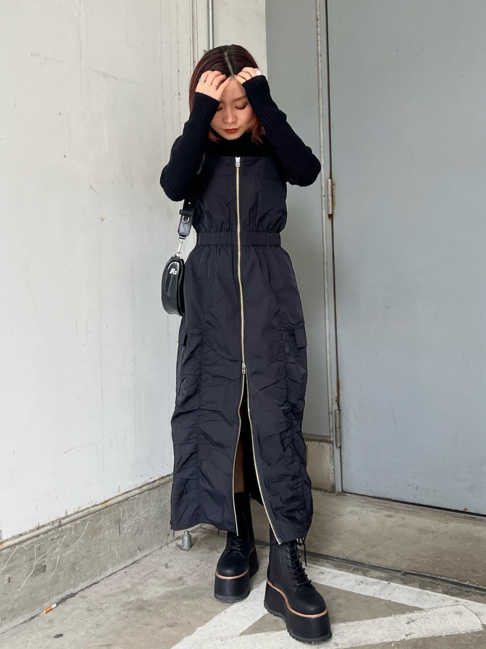 ブラック系のワンピース、ブラック系のブーツ、ブラック系のニット/セーターを着用したレディースの冬コーディネートの1枚目の写真