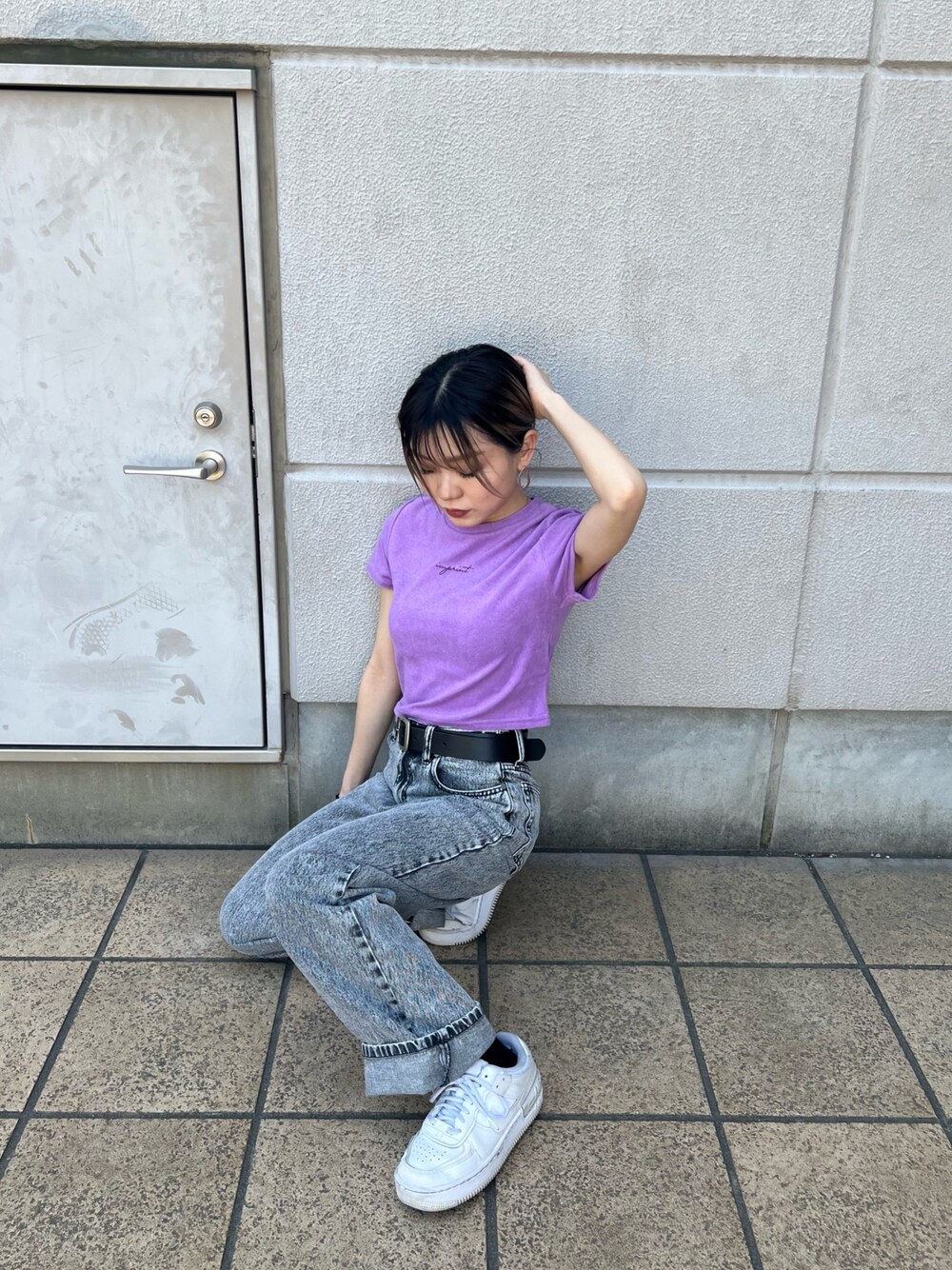 グレー系のデニムパンツ、パープル系のTシャツ/カットソー、ブラック系のベルトを着用したレディースの春コーディネートの1枚目の写真