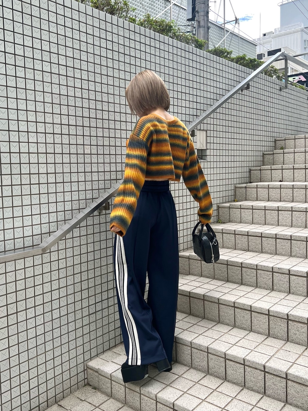 パープル系のカーディガン/ボレロ、ブラック系のブーツ、ブルー系のその他パンツを着用したレディースの秋コーディネートの1枚目の写真