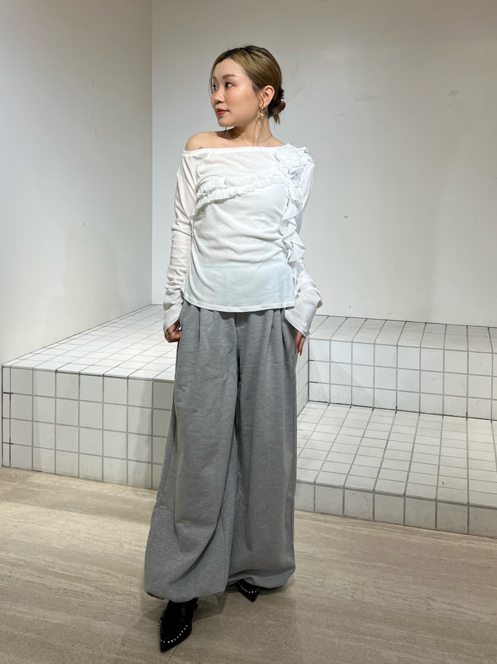 ホワイト系のTシャツ/カットソー、グレー系のその他パンツ、ブラック系のサンダルを着用したレディースの春コーディネートの1枚目の写真