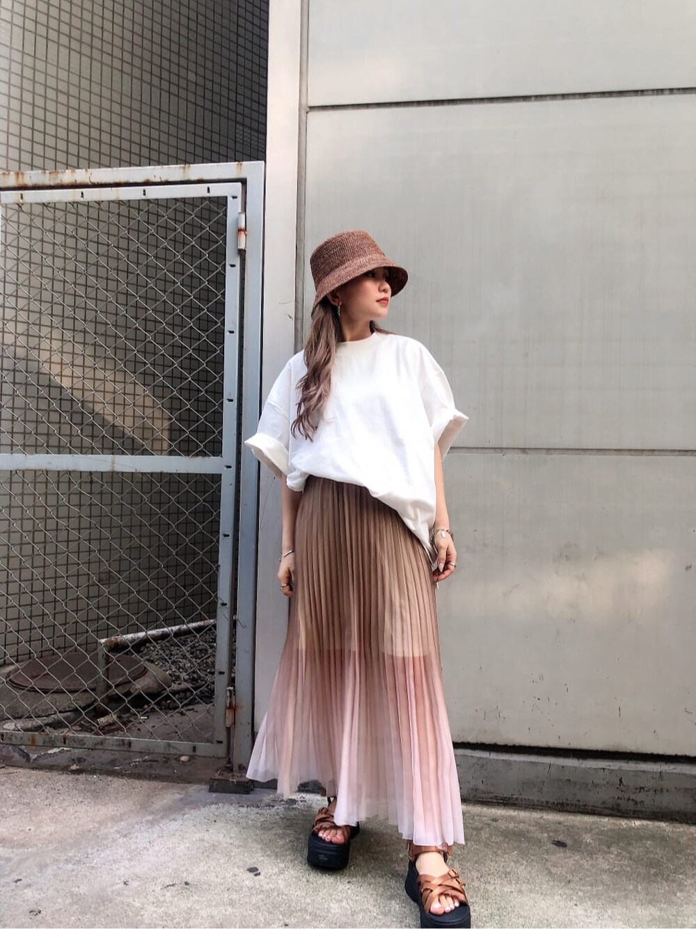 ブラック系のサンダル、ホワイト系のTシャツ/カットソー、ベージュ系のスカートを着用したレディースの夏コーディネートの1枚目の写真