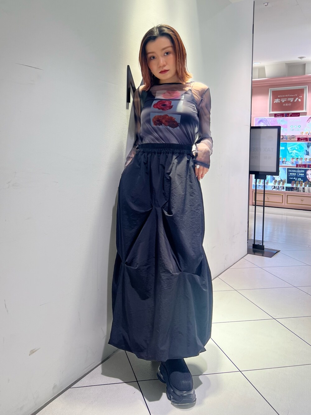 ブラック系のTシャツ/カットソー、ブラック系のスカート、ブラック系のブーツを着用したレディースの春コーディネートの1枚目の写真