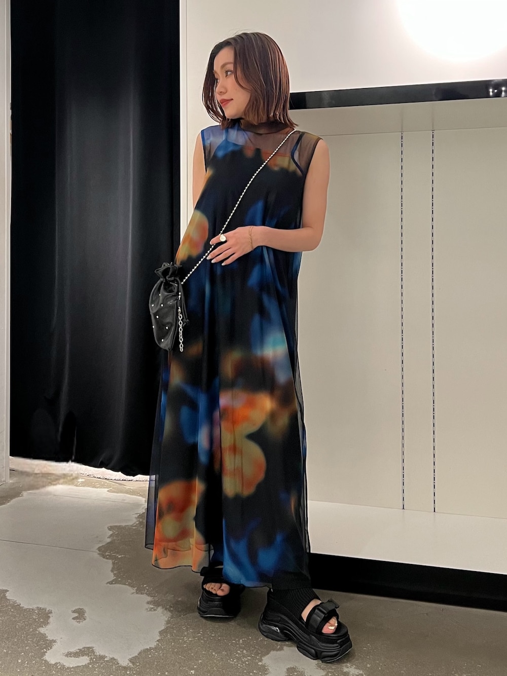 ブラック系のワンピース、ブラック系のサンダル、ブラック系のショルダーバッグを着用したレディースの春コーディネートの1枚目の写真