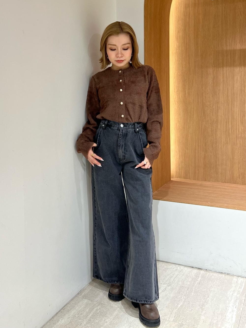 ブラウン系のカーディガン/ボレロ、ブラック系のデニムパンツ、ブラウン系のブーツを着用したレディースの冬コーディネートの1枚目の写真