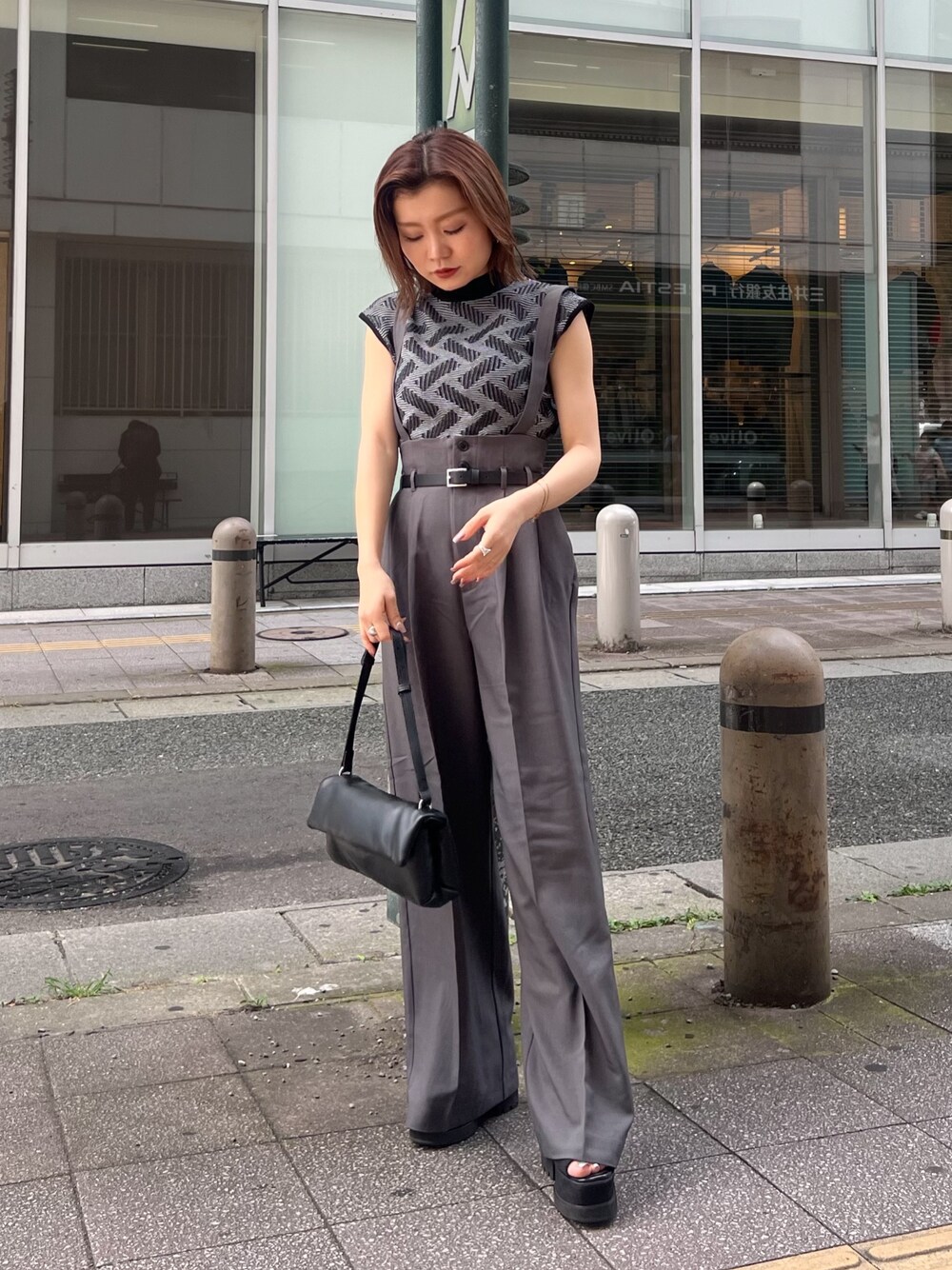 ブラック系のニット/セーター、グレー系のその他パンツ、ブラック系のハンドバッグを着用したレディースの夏コーディネートの1枚目の写真
