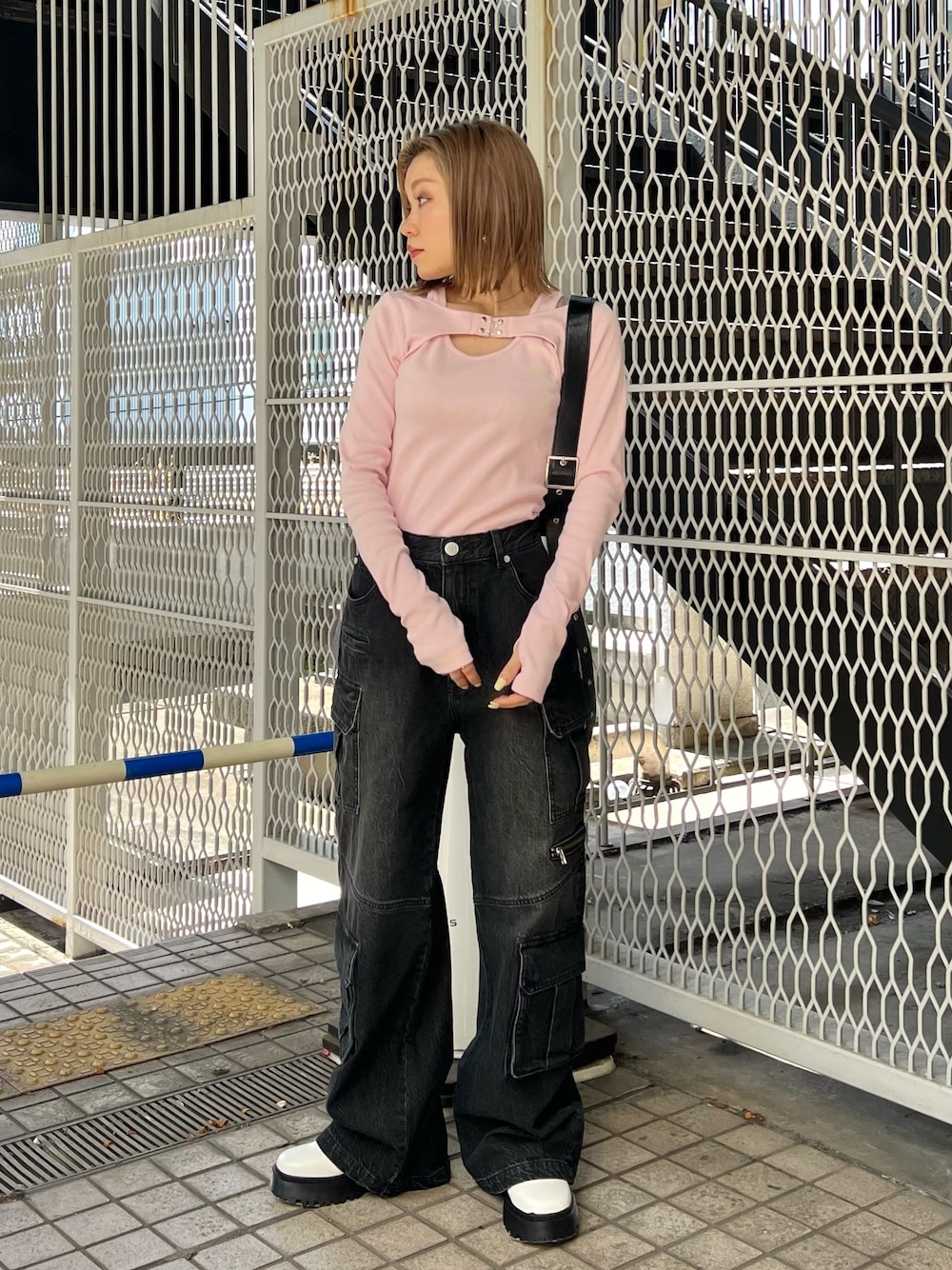 ピンク系のTシャツ/カットソー、ブラック系のデニムパンツ、ホワイト系のブーツを着用したレディースの冬コーディネートの1枚目の写真