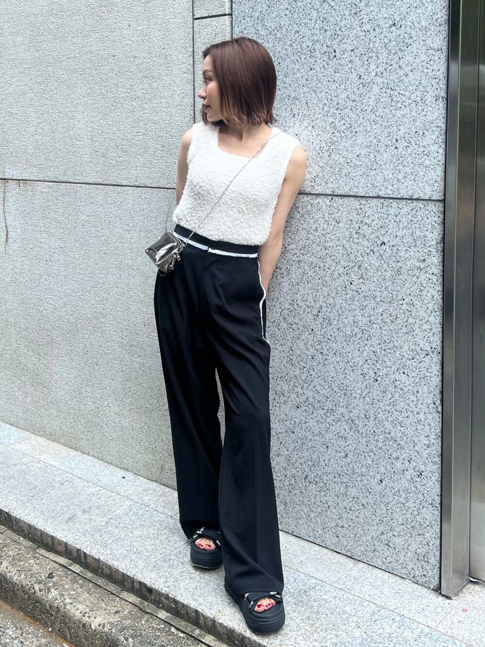 ホワイト系のニット/セーター、ブラック系のその他パンツ、ゴールド系のショルダーバッグを着用したレディースの夏コーディネートの1枚目の写真