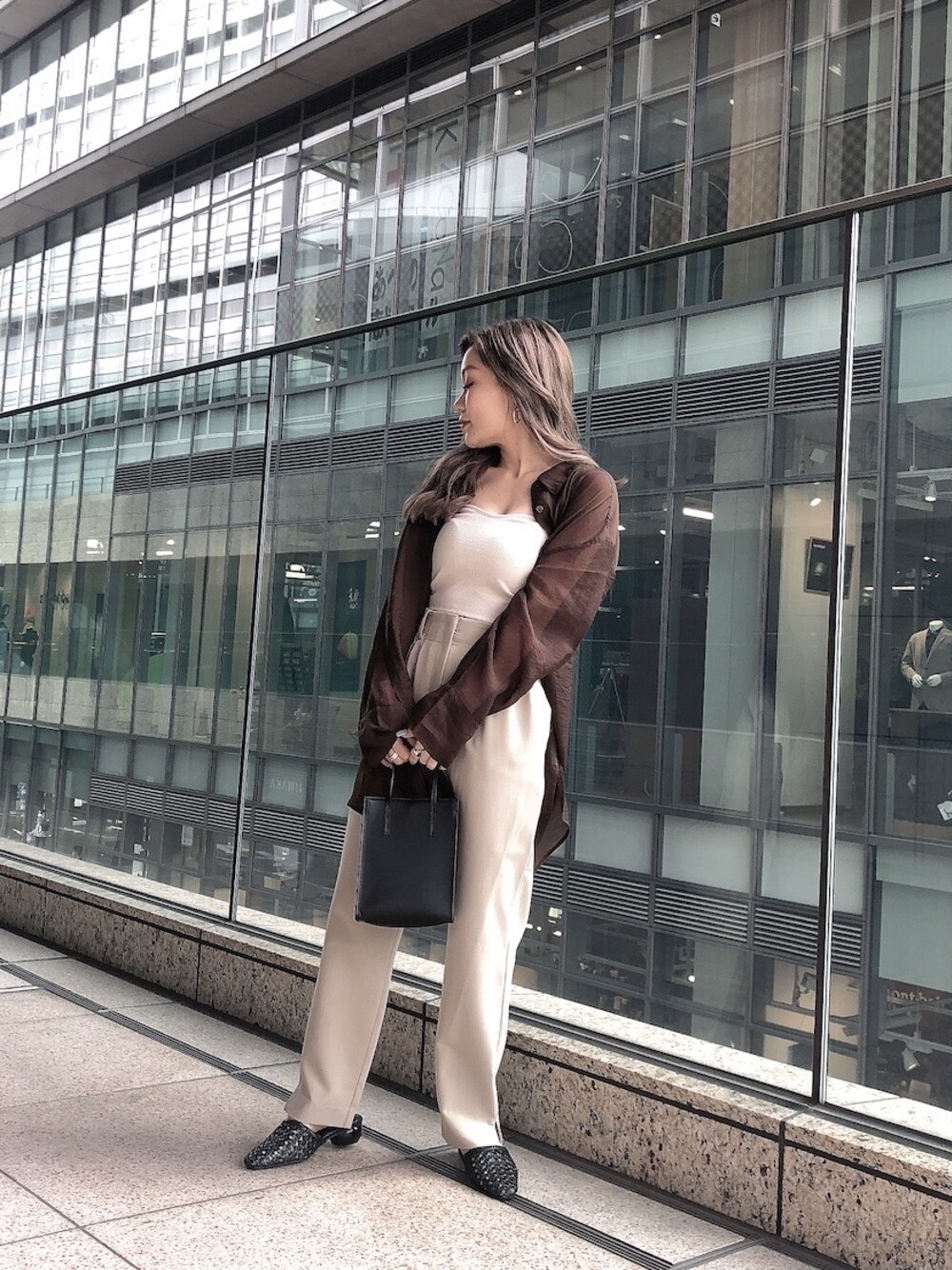ベージュ系のシャツ/ブラウス、ベージュ系のその他パンツ、ブラック系のショルダーバッグを着用したレディースの春コーディネートの1枚目の写真