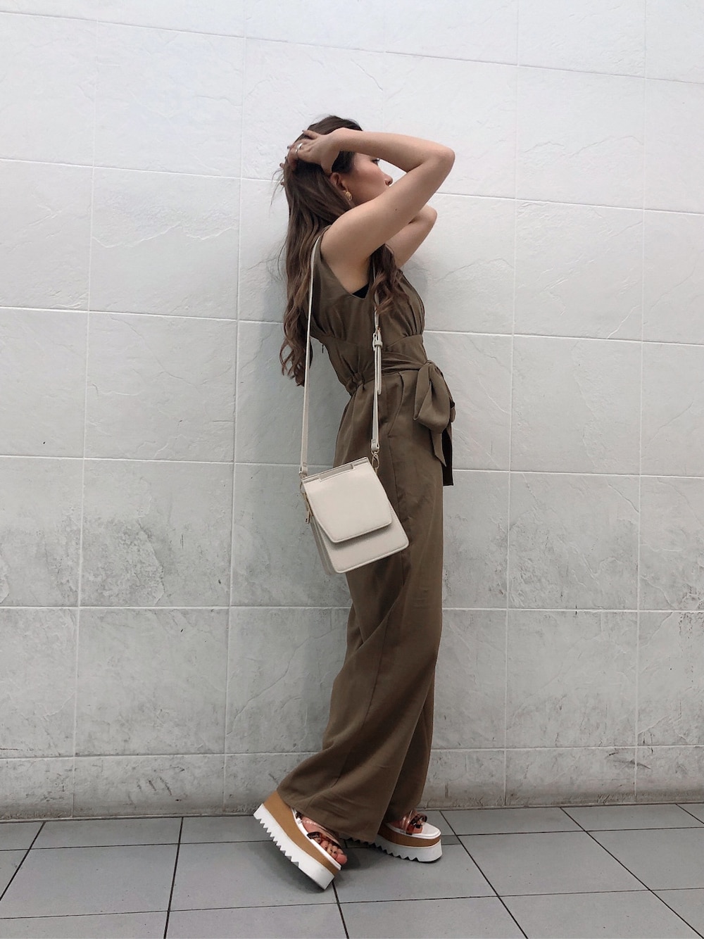 ホワイト系のサンダル、ホワイト系のハンドバッグ、ベージュ系のつなぎ/オールインワンを着用したレディースの夏コーディネートの1枚目の写真
