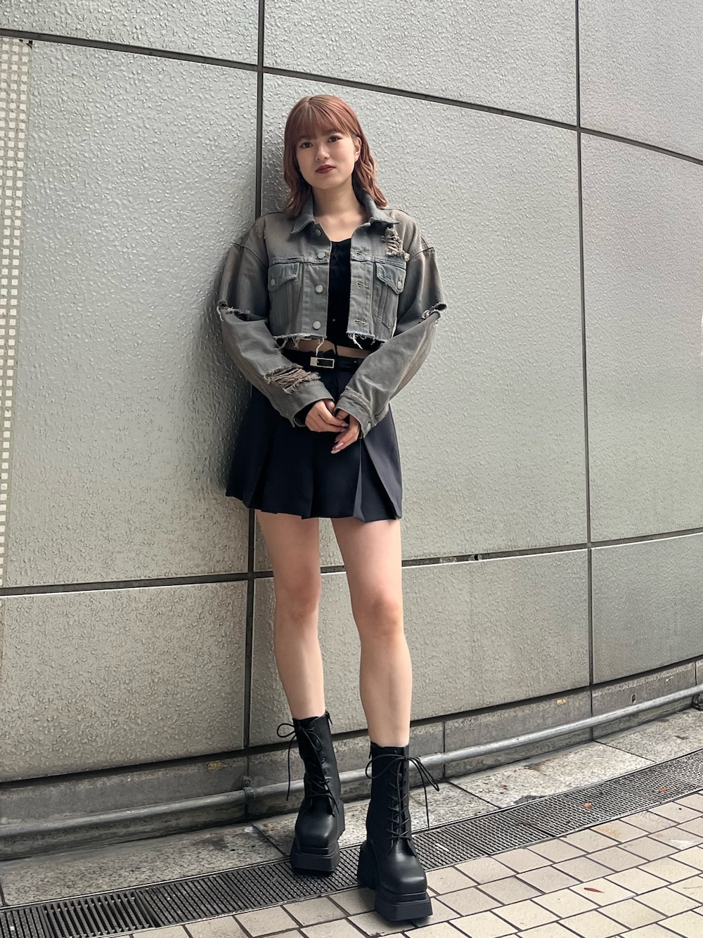 ブラック系のニット/セーター、グレー系のスカート、ブラック系のブーツを着用したレディースの冬コーディネートの1枚目の写真