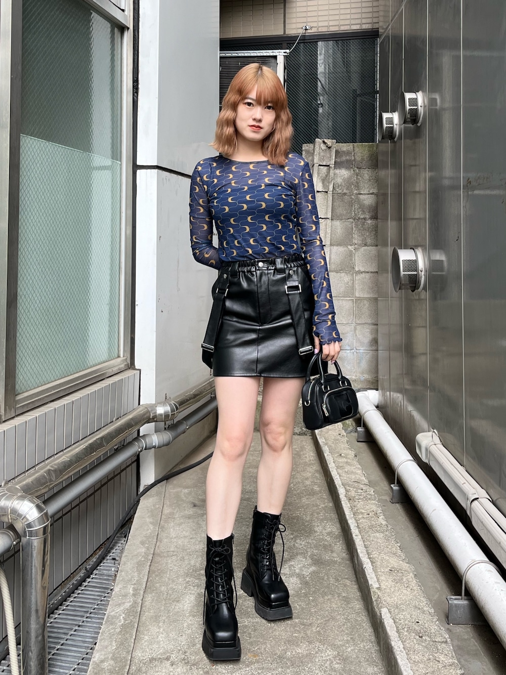 ブラック系のブーツ、ブラック系のスカート、その他のTシャツ/カットソーを着用したレディースの冬コーディネートの1枚目の写真