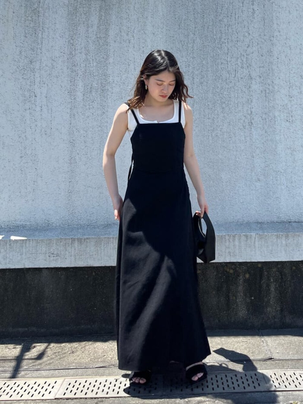ブラック系のワンピース、ホワイト系のタンクトップ、ブラック系のサンダルを着用したレディースの夏コーディネートの1枚目の写真