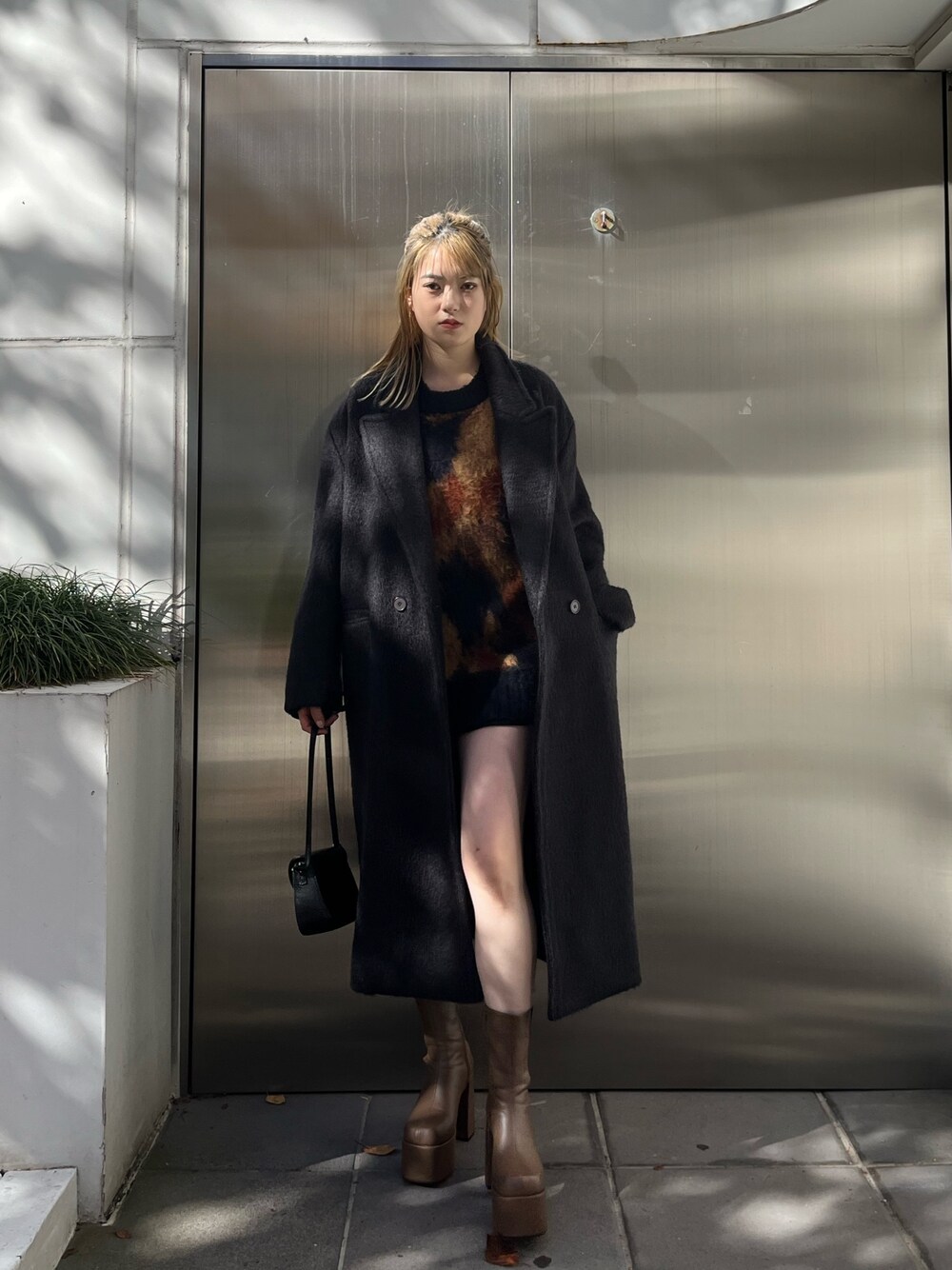 その他のニット/セーター、ブラック系のスカート、ブラウン系のブーツを着用したレディースの冬コーディネートの1枚目の写真