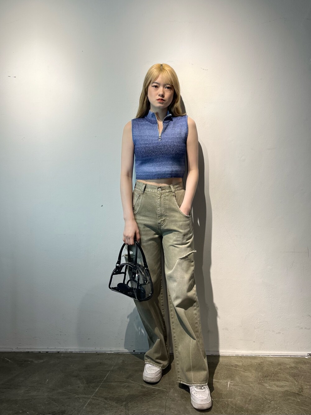 ベージュ系のデニムパンツ、その他のハンドバッグ、ブルー系のタンクトップを着用したレディースの春コーディネートの1枚目の写真