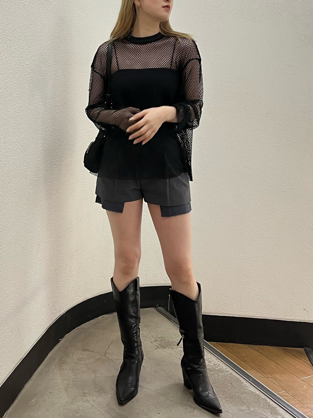 ブラック系のブーツ、ブラック系のキャミソール、ブラック系のハンドバッグを着用したレディースの夏コーディネートの1枚目の写真