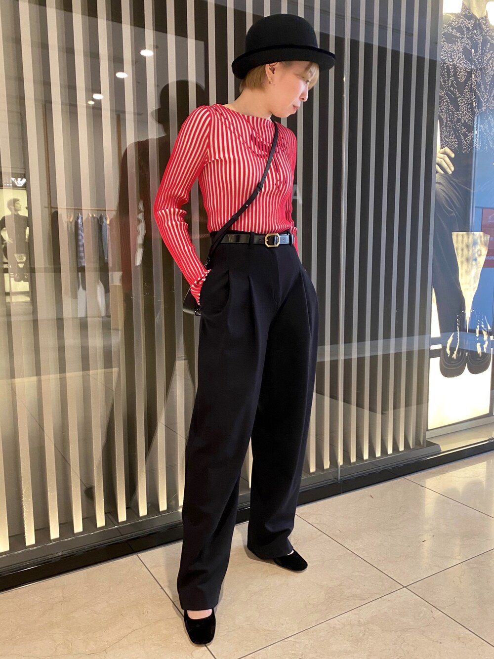 ブラック系のパンプス、レッド系のニット/セーター、ブラック系のパンツを着用したレディースの秋コーディネートの1枚目の写真