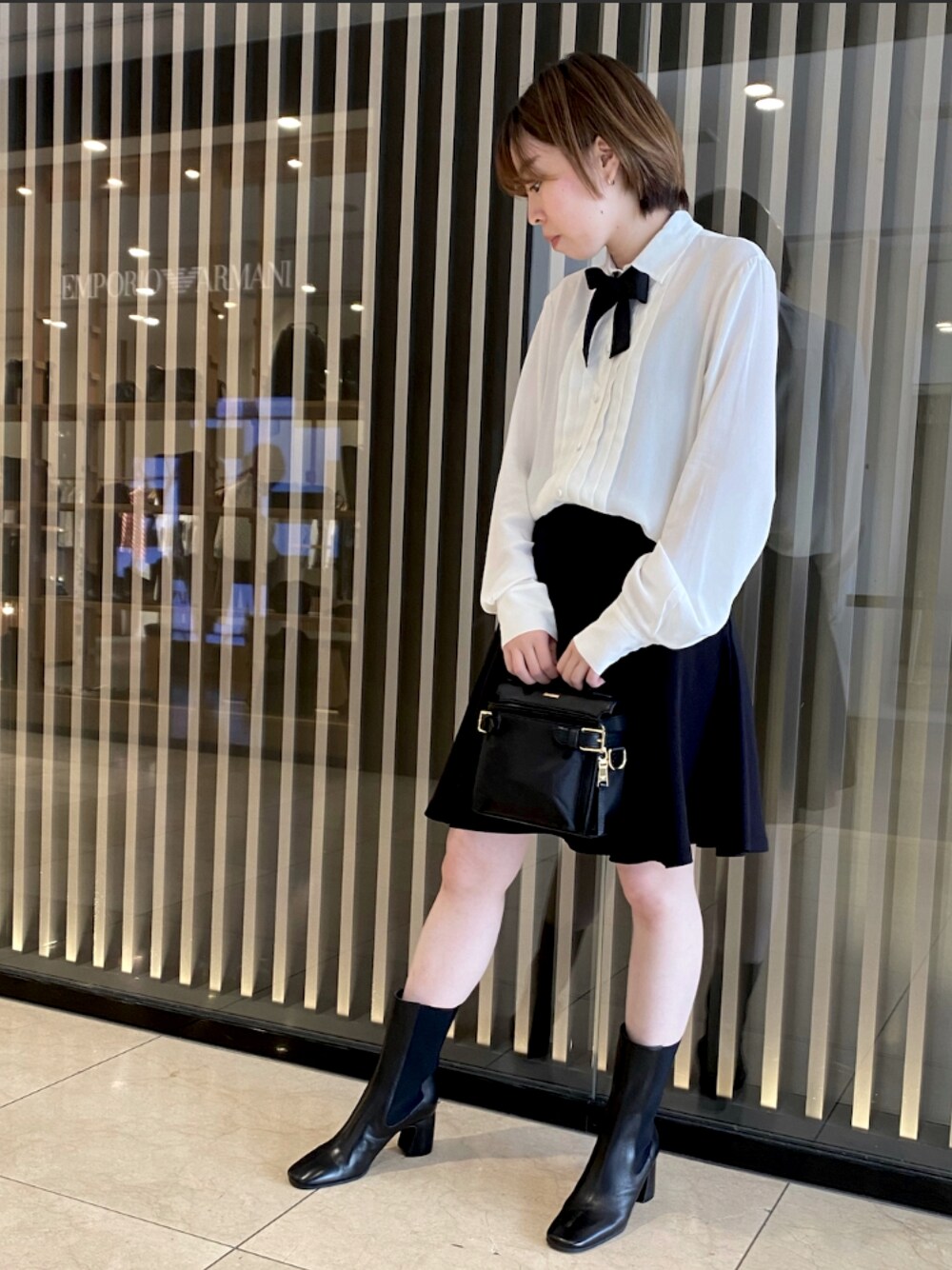 ホワイト系のシャツ/ブラウス、ブラック系のバッグ、ブラック系のスカートを着用したレディースの秋コーディネートの1枚目の写真
