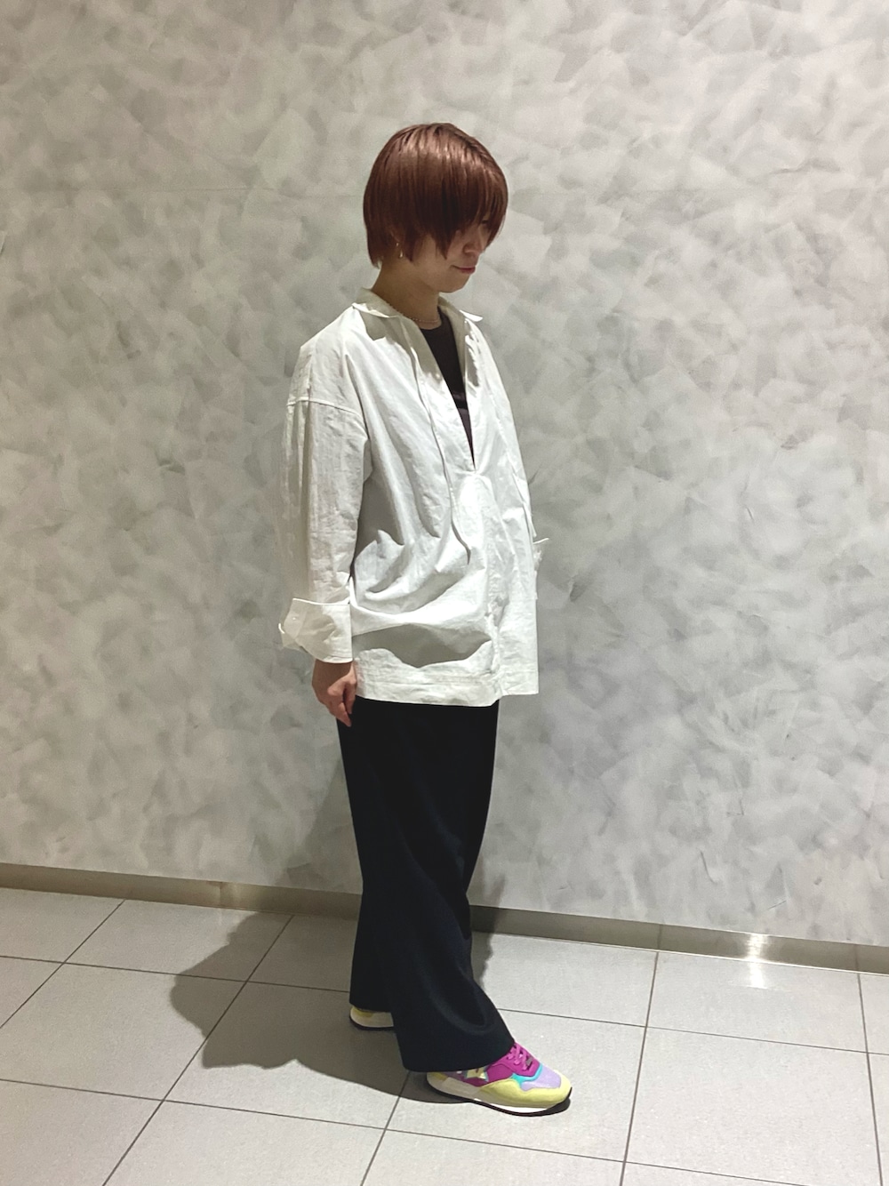 ブラック系のスニーカーを着用したレディースの春コーディネートの1枚目の写真