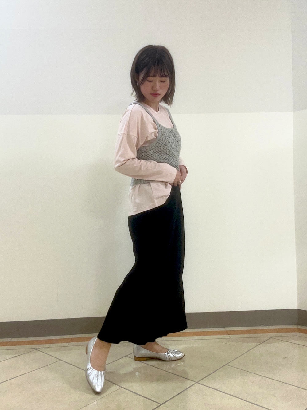 シルバー系のパンプスを着用したレディースの春コーディネートの1枚目の写真