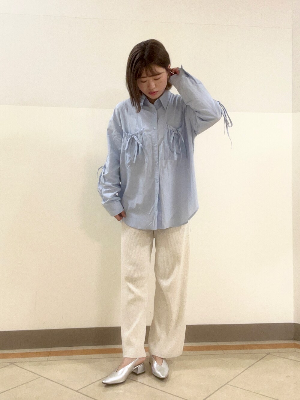 シルバー系のパンプスを着用したレディースの春コーディネートの1枚目の写真