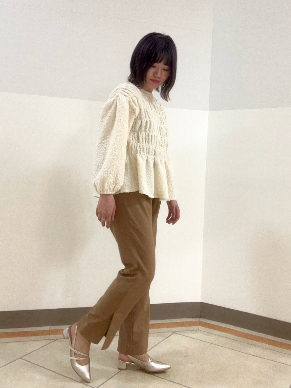 シルバー系のパンプスを着用したレディースの春コーディネートの1枚目の写真