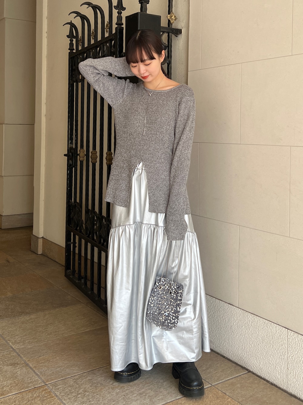ブラック系のブーツ、シルバー系のスカート、グレー系のTシャツ/カットソーを着用したレディースの冬コーディネートの1枚目の写真