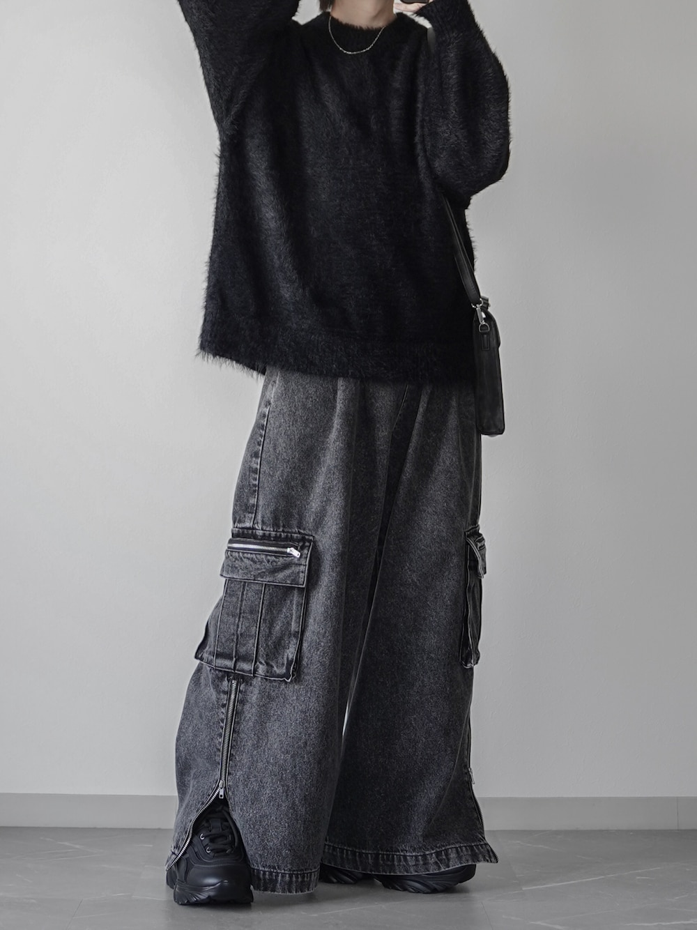 ブラック系のニット/セーター、ブラック系のカーゴパンツ、ブラック系のショルダーバッグを着用したメンズの秋コーディネートの1枚目の写真