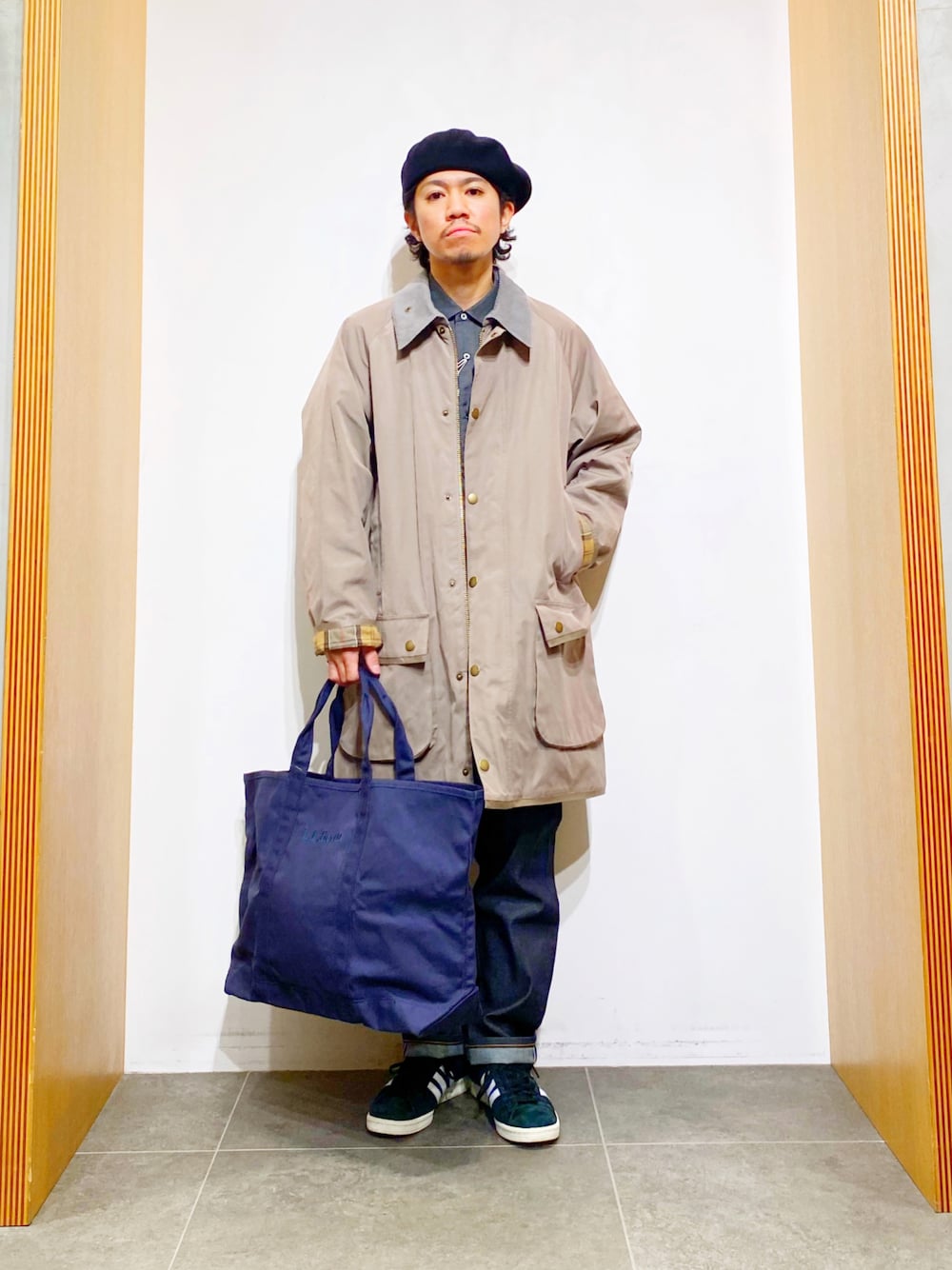 ブルー系のステンカラーコート、グレー系のシャツ/ブラウス、グレー系のトートバッグを着用したメンズの冬コーディネートの1枚目の写真