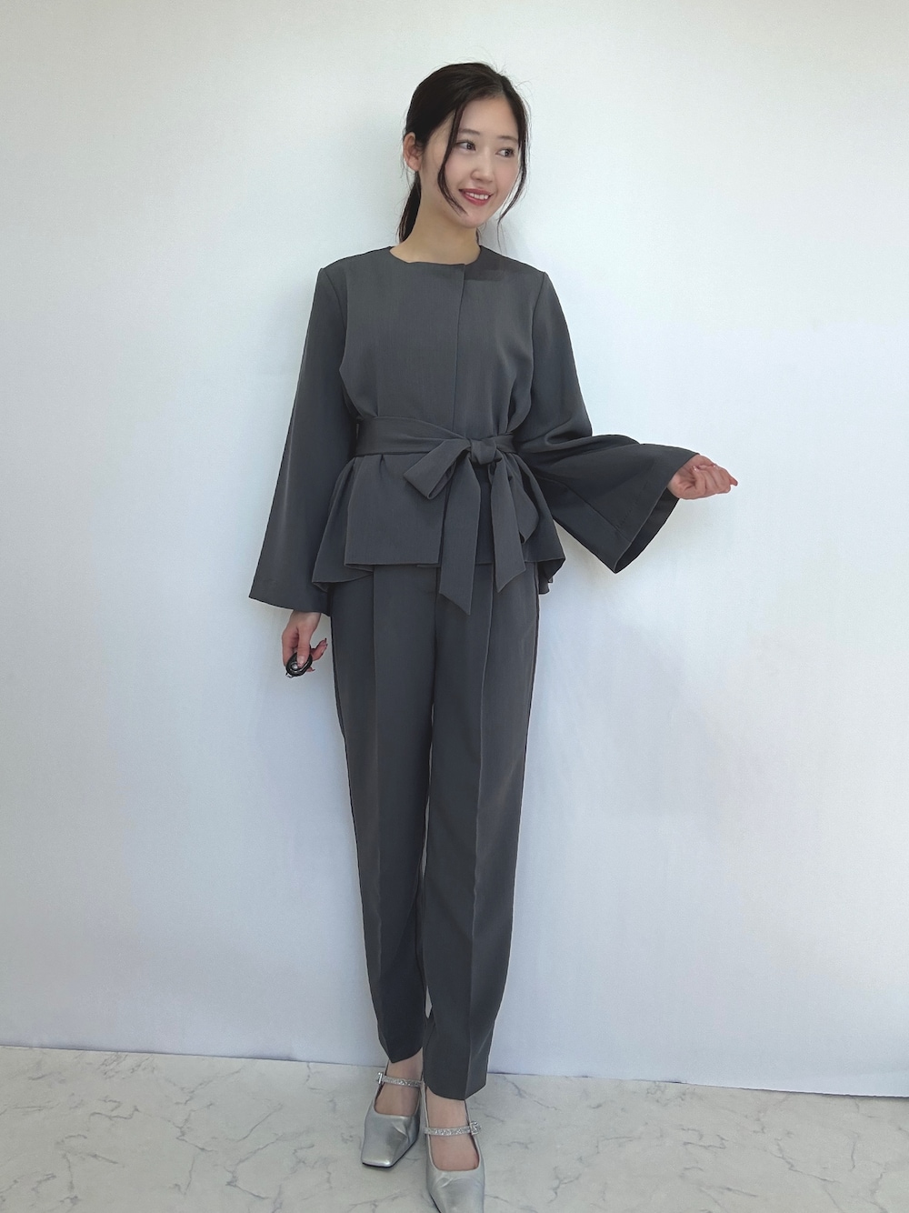 グレー系のスーツセットを着用したレディースの冬コーディネートの1枚目の写真