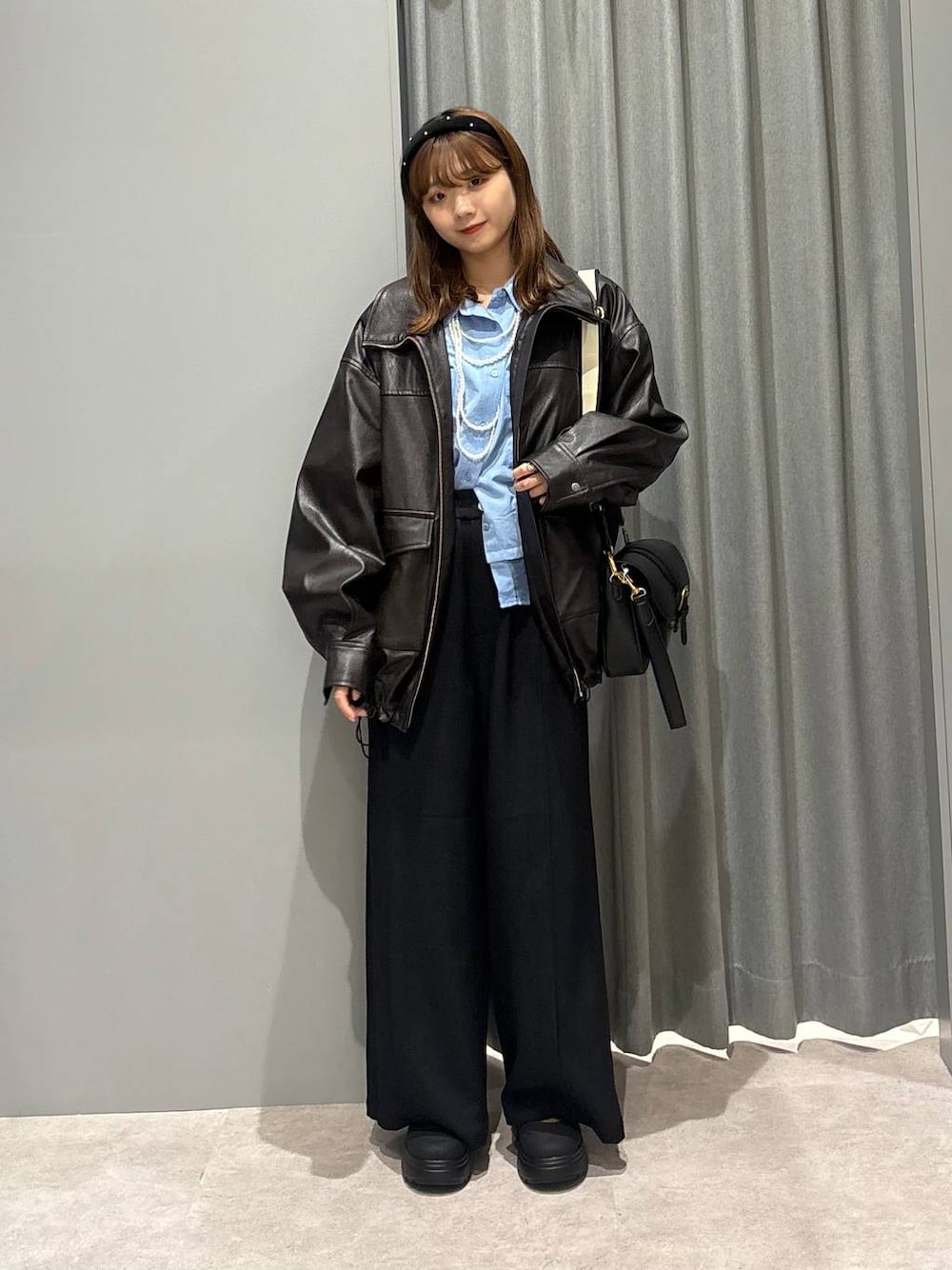 ブラック系のショルダーバッグ、ブルー系のシャツ/ブラウス、ブラウン系のブルゾンを着用したレディースの秋コーディネートの1枚目の写真