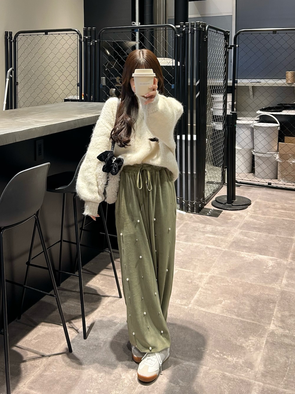 グリーン系のその他パンツ、ホワイト系のニット/セーター、ホワイト系のショルダーバッグを着用したレディースの冬コーディネートの1枚目の写真