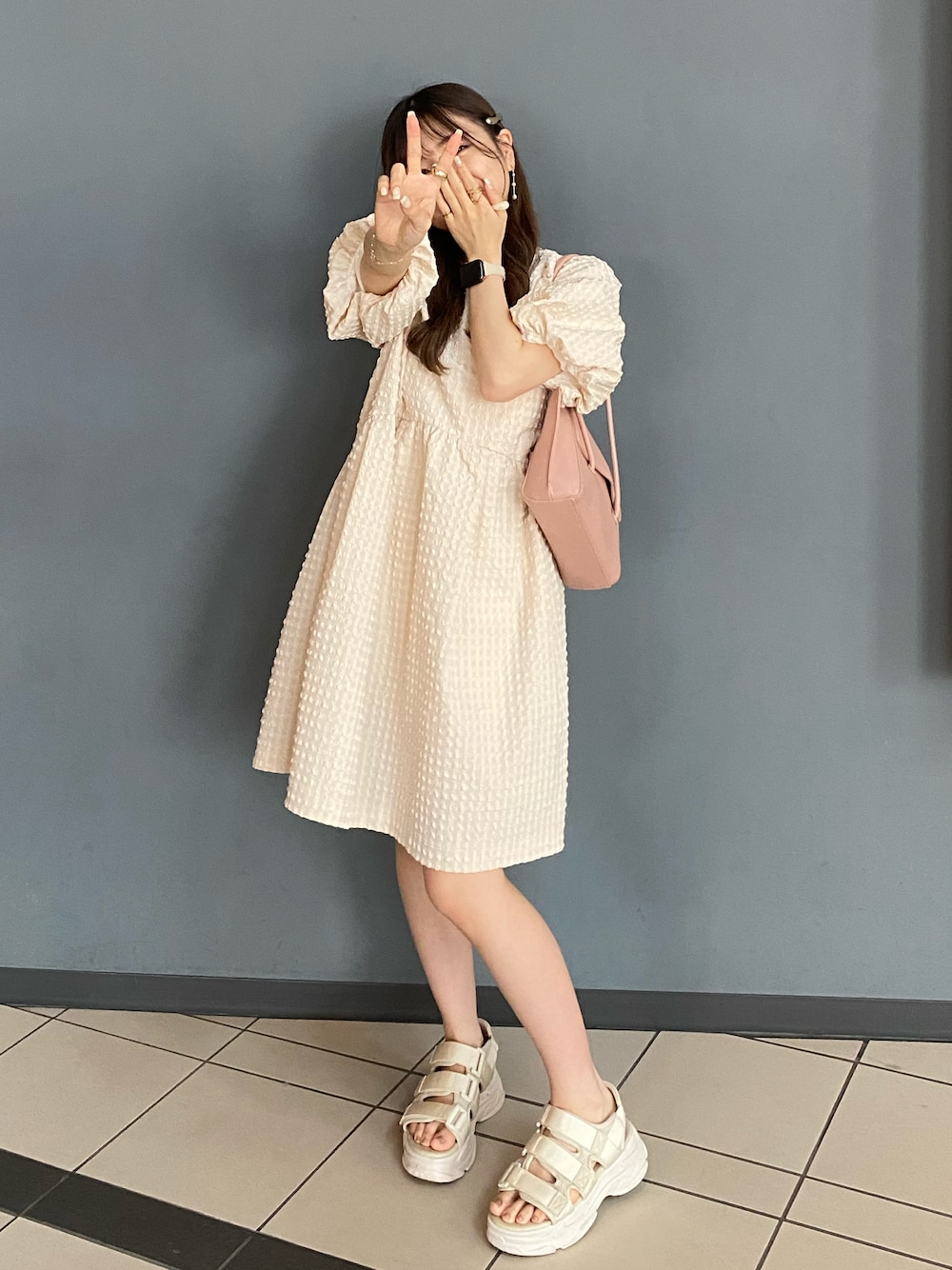 ホワイト系のサンダル、ピンク系のショルダーバッグ、ホワイト系のシャツ/ブラウスを着用したレディースの夏コーディネートの1枚目の写真