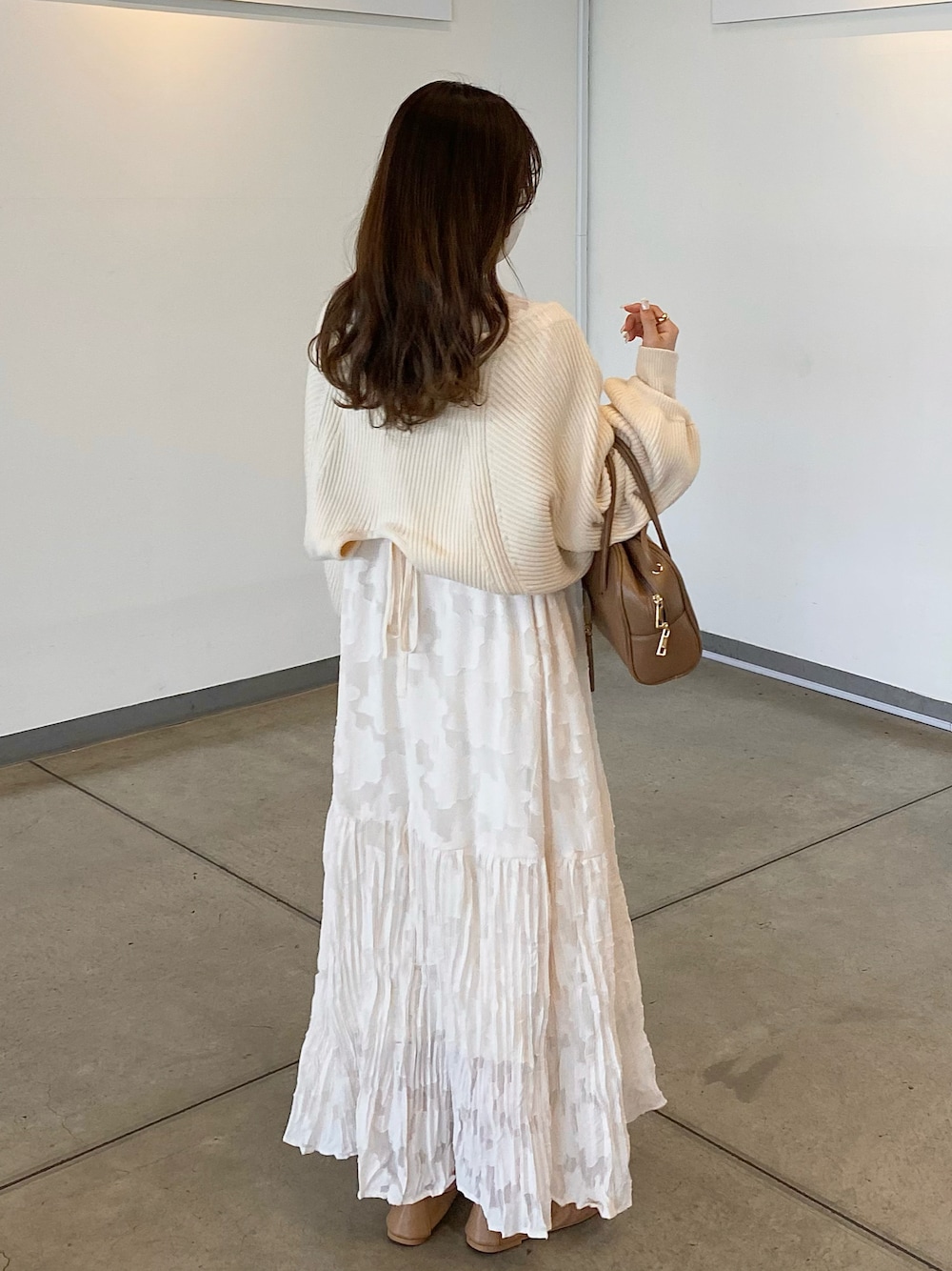 ブラウン系のバッグ、ホワイト系のカーディガン/ボレロ、ブラウン系のドレスシューズを着用したレディースの春コーディネートの1枚目の写真