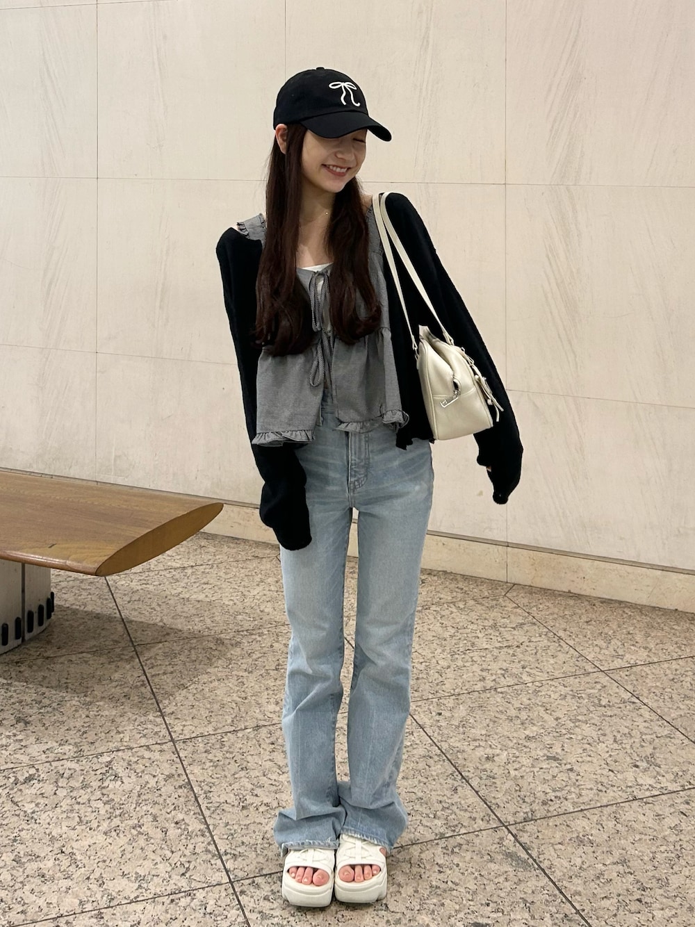 ブルー系のデニムパンツ、ホワイト系のショルダーバッグ、ベージュ系のサンダルを着用したレディースの夏コーディネートの1枚目の写真