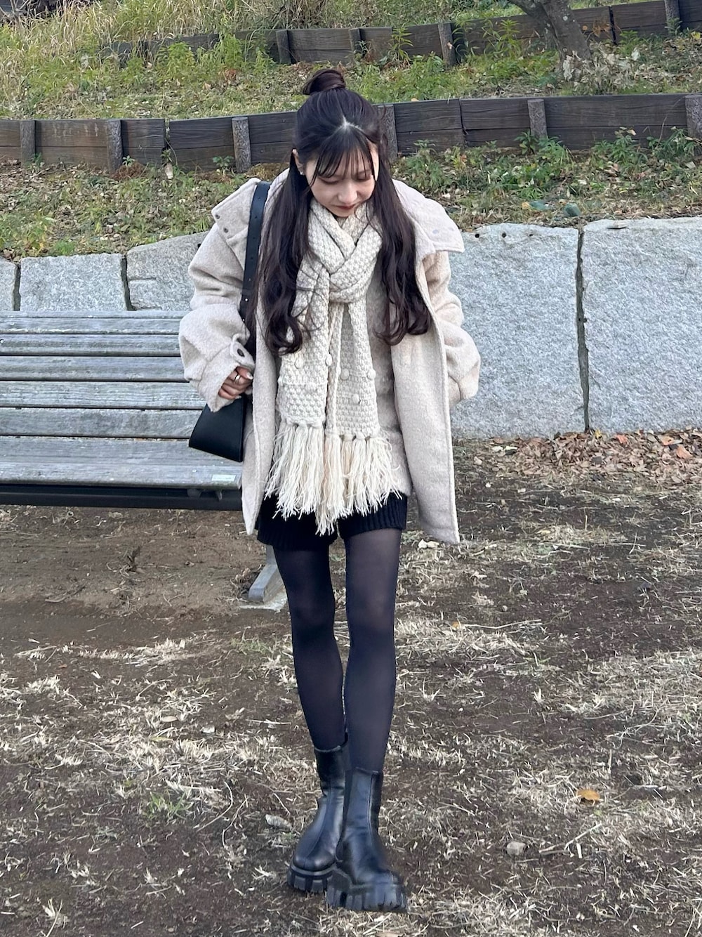 ホワイト系のダッフルコート、ブラック系のショルダーバッグ、ブラック系のブーツを着用したレディースの冬コーディネートの1枚目の写真