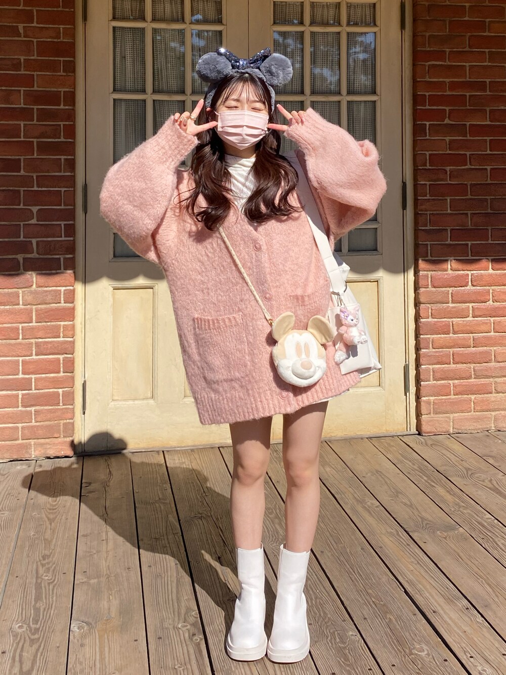 ピンク系のカーディガン/ボレロ、ホワイト系のTシャツ/カットソー、ブラック系のその他パンツを着用したレディースの秋コーディネートの1枚目の写真