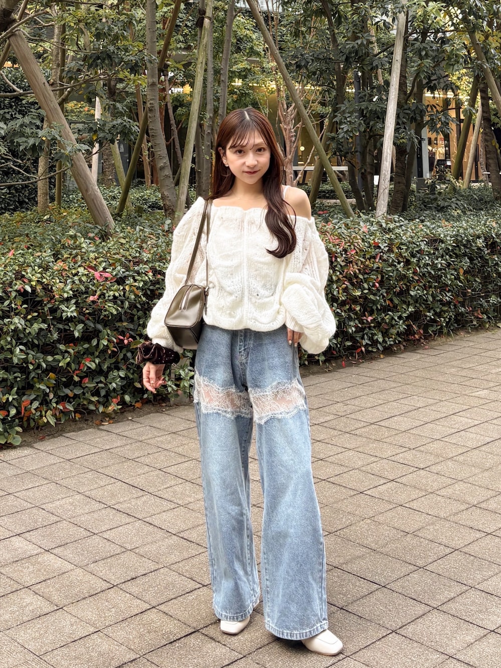 ホワイト系のニット/セーター、ブルー系のデニムパンツ、グリーン系のトートバッグを着用したレディースの秋コーディネートの1枚目の写真