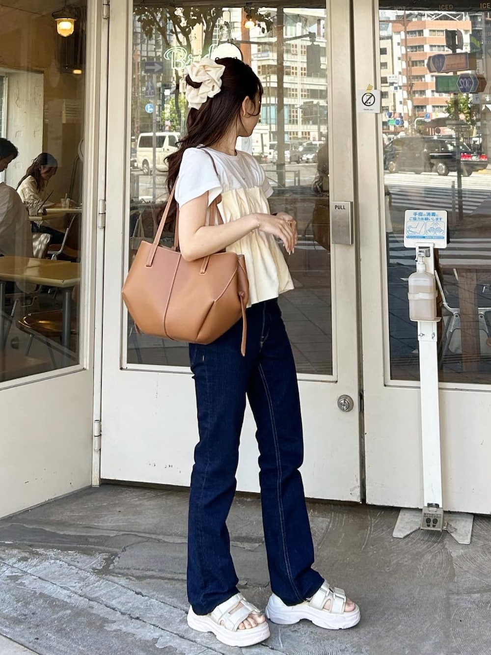 ブラウン系のバッグ、ホワイト系のサンダル、ホワイト系のTシャツ/カットソーを着用したレディースの夏コーディネートの1枚目の写真