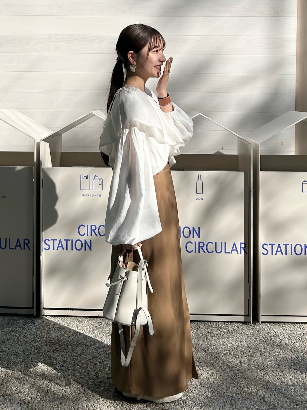 ホワイト系のシャツ/ブラウス、ブラウン系のスカート、ホワイト系のバッグを着用したレディースの春コーディネートの1枚目の写真